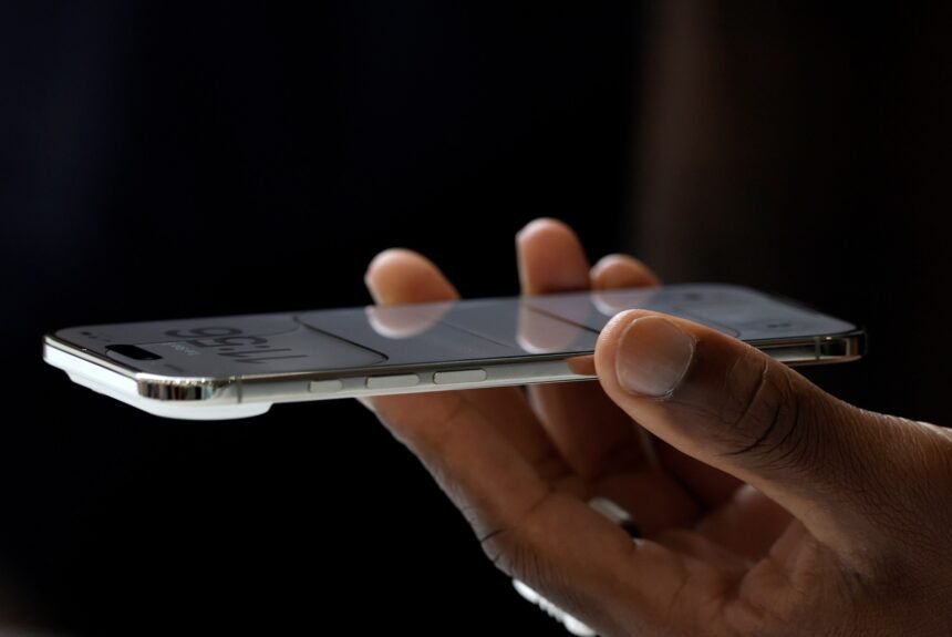 A hand holding the iPhone Air, which is 5.6 millimeters thin, meaningfully thinner than the 8.2-millimeter-thin iPhone 17 Pro.
