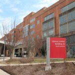 A photo of the exterior of the NIH Clinical Center. A red sign out front identifies it as Building 10.