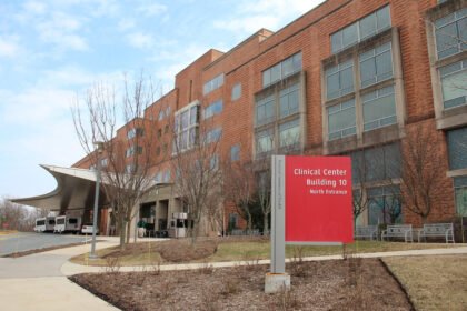 A photo of the exterior of the NIH Clinical Center. A red sign out front identifies it as Building 10.